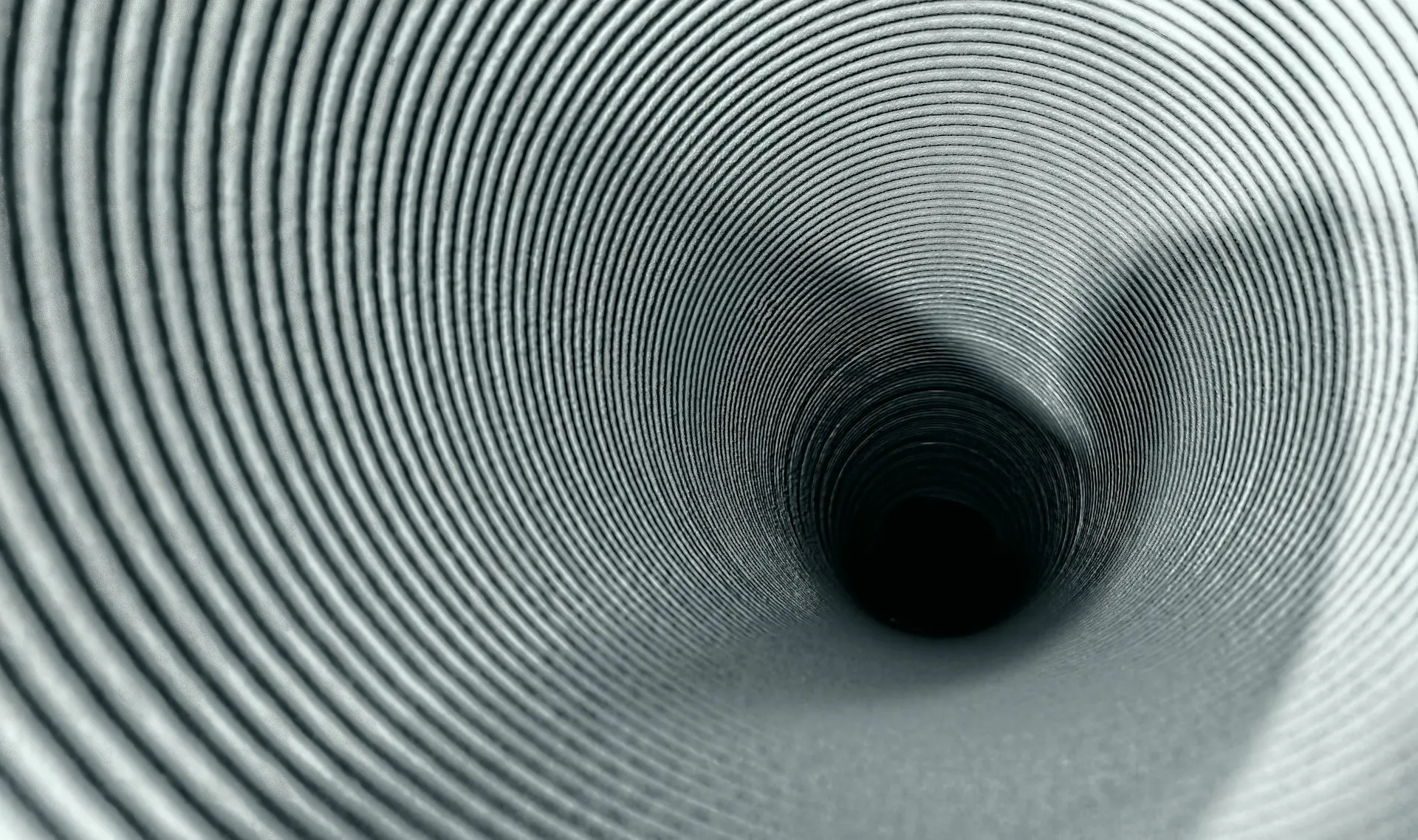 A deep spiral staircase viewed from above